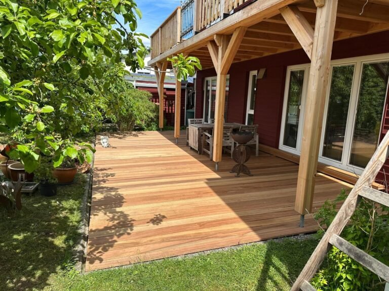 Terrasse aus Guyana Teak mit Blick in den Garten, darueber der Balkon